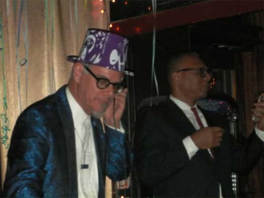 Phast Phreddie the Boogaloo Omnibus cues "Auld Lang Syne" as Gaylord Fields keeps an eye on the time at the DYNAGROOVE NEW YEAR'S EVE SPECTACULAR!